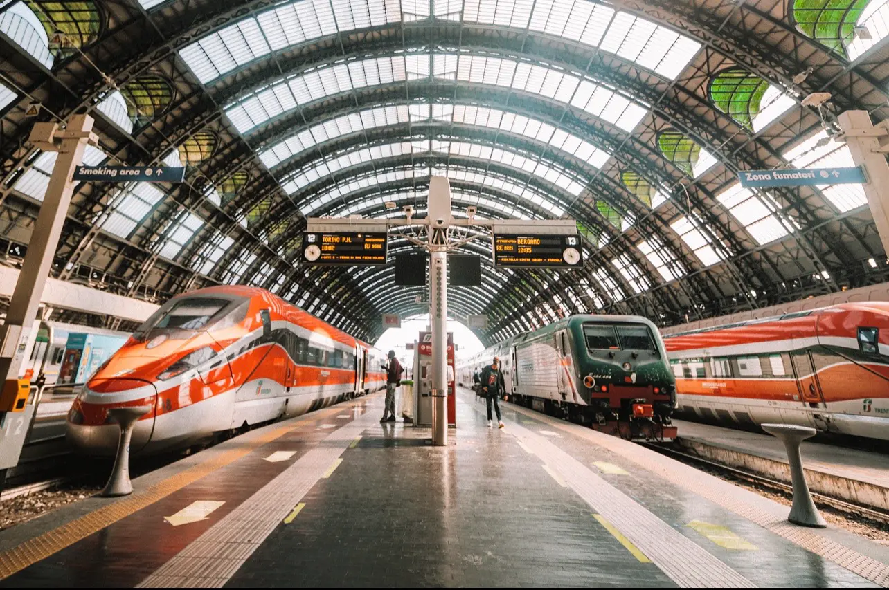 Red trains beneath a grand station roof